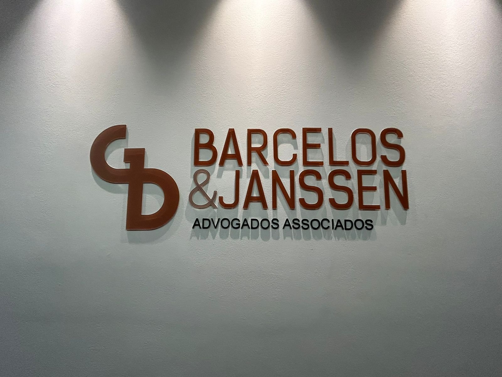 Letreiro interno Barcelos e Janssen Advogados Associados aplicado em parede clara.