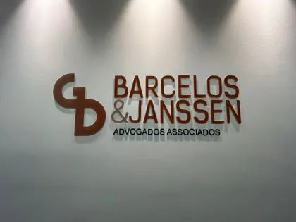 Miniatura: Letreiro interno da Barcelos e Janssen Advogados Associados com letras em relevo sobre parede clara.