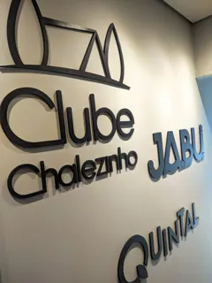 Miniatura: Vista aproximada dos letreiros Clube Chalezinho, Jabui e Quintal com profundidade e sombra lateral.